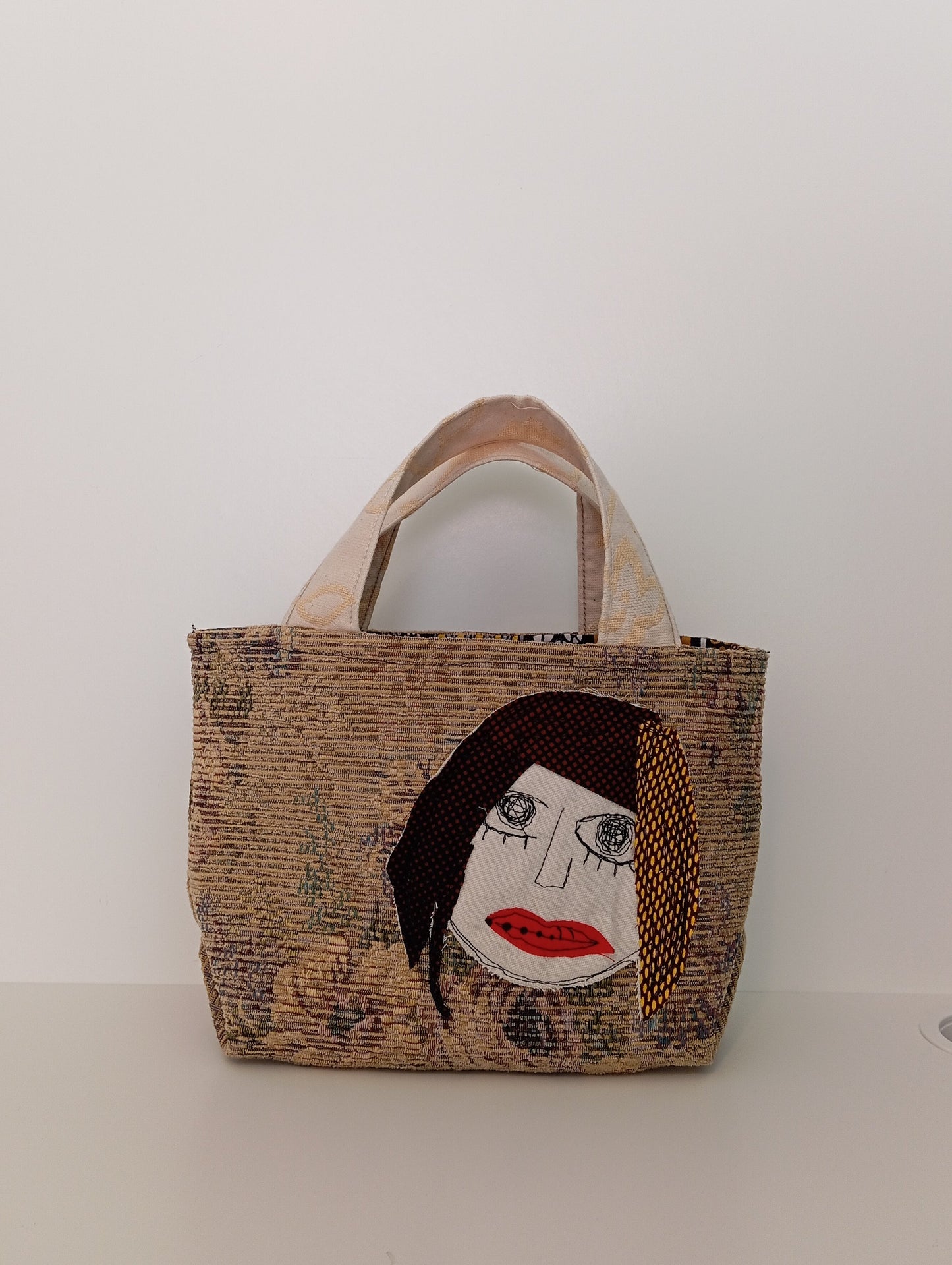 Borsellino artigianale in tessuti riciclati con ricami a mano – GELTRUDE